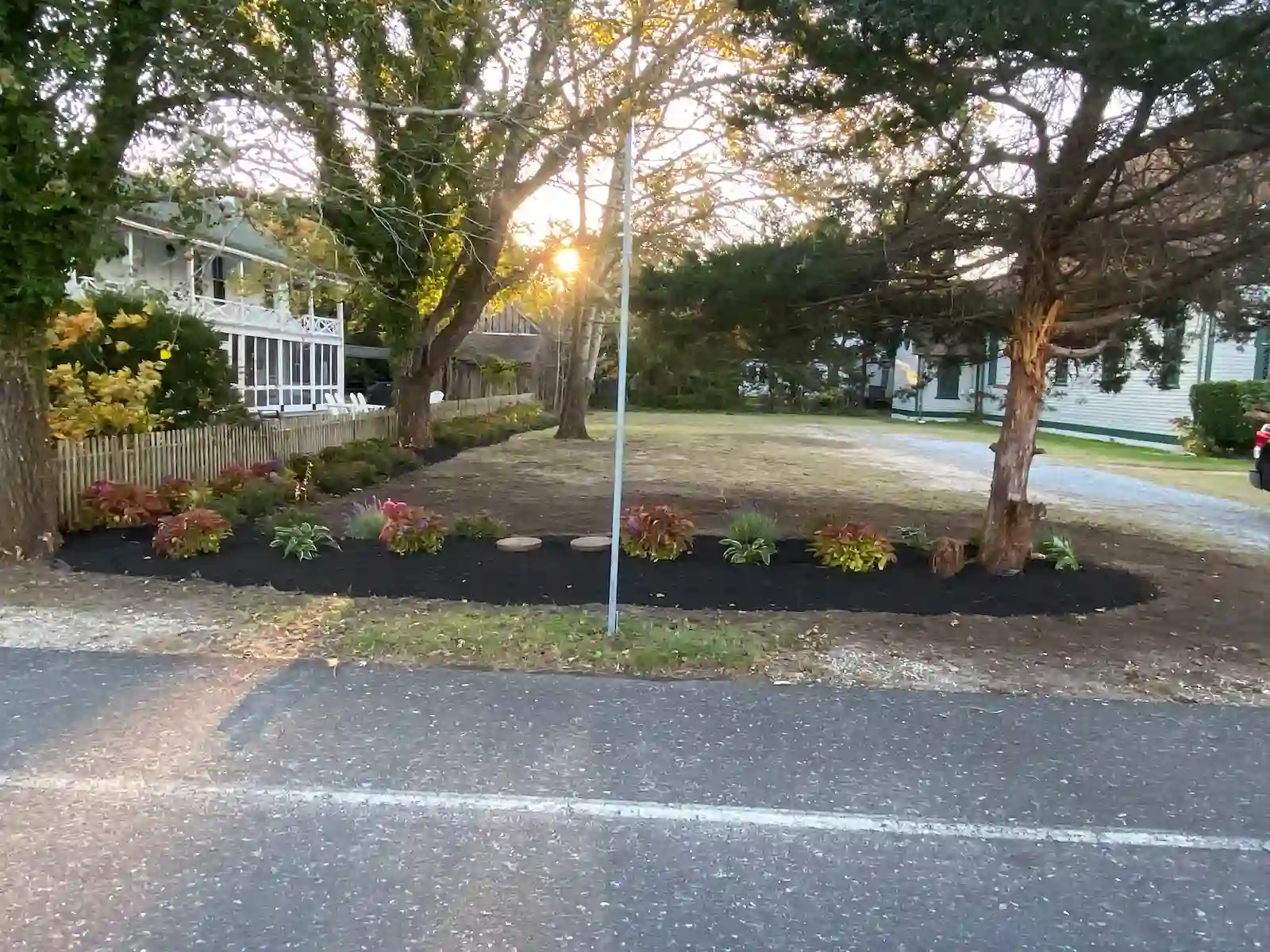 Front yard mulch installation completed by Green Harmony Landscaping, shown at sunset for enhanced depth and color.
